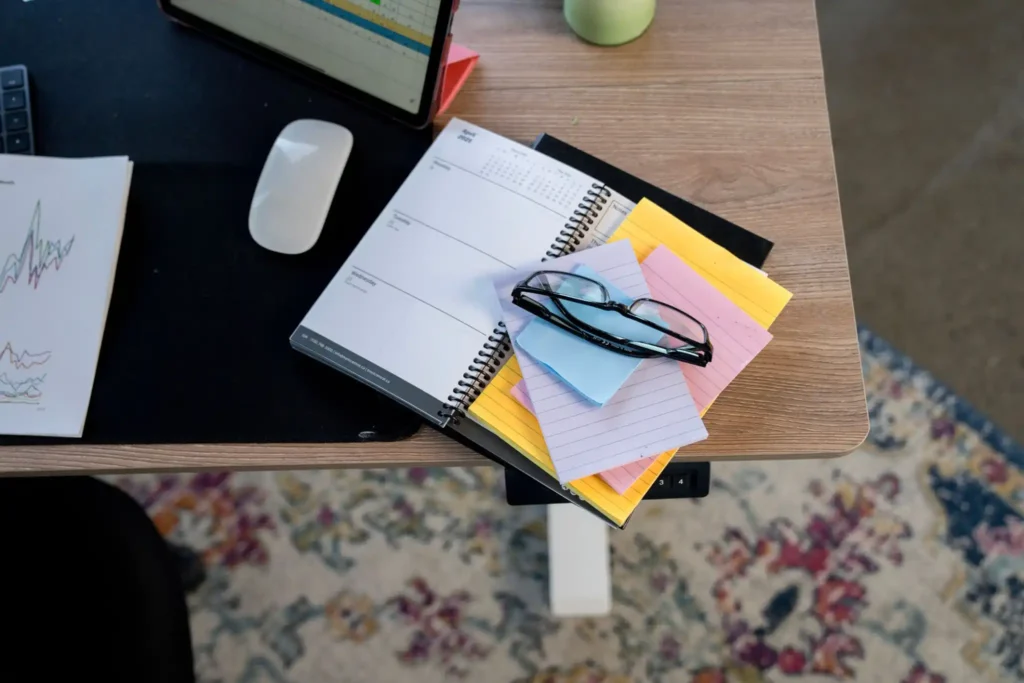 Organized office desk with a task planner and sticky notes.