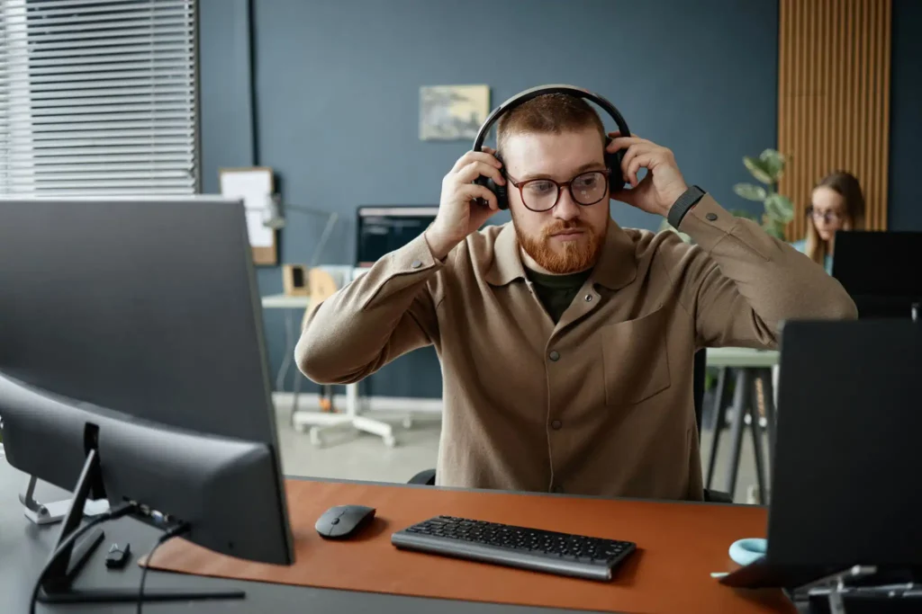 Office worker using noise-canceling headphones as an ADHD accommodation